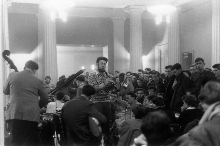 black and white photograph of a jazz band playing in a crowded room